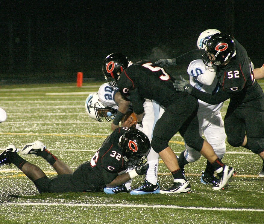 Camas seniors Kamari Brown (32), Anthony Fallin (5) and Scott Feather (52) serve Meadowdale a Papermaker sandwich.