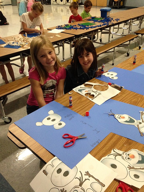 Maya Hopkins and Lillian Grindy enjoy constructing Olaf, the snowman from "Frozen," at a recent camp. Participants also made snowman soup, wands, princess crowns, built castles out of real ice and decorated snowflakes.