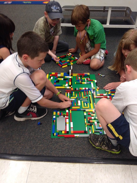 Campers work together to make a giant Lego maze during a summer camp. Teaching children collaboration is one of the skills emphasized by staff at BrickZoneKids.