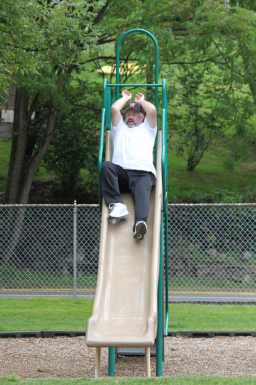 Washougal Mayor Sean Guard takes his turn on the slide during a Father's Day obstacle course, part of the Camas and Washougal on a Diet challenge.  Keeping workouts fun and varied are two keys to maintaining an exercise regimen.