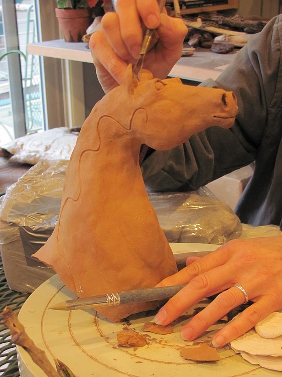 Wiancko-Chasman adds details to a clay horse.  She is often inspired by a love of animals.