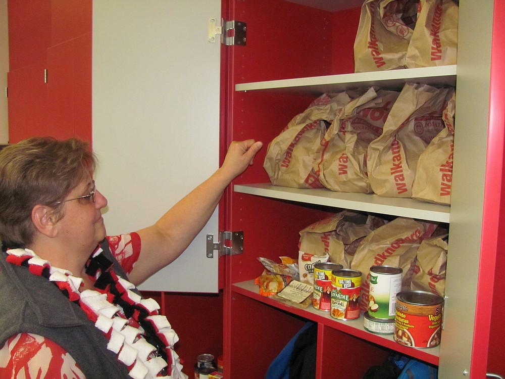 Edie Hagstrom, social worker at Helen Baller Elementary School, prepares bags of food for the school's weekend backpack program, which provides easy to prepare meals and snacks for children in need.