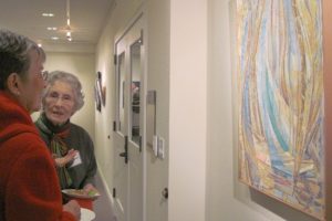 Susan Smith, right, discusses her artwork with an attendee at a First Friday reception. Smith is the featured December artist at the Second Story gallery at the Camas Public Library.