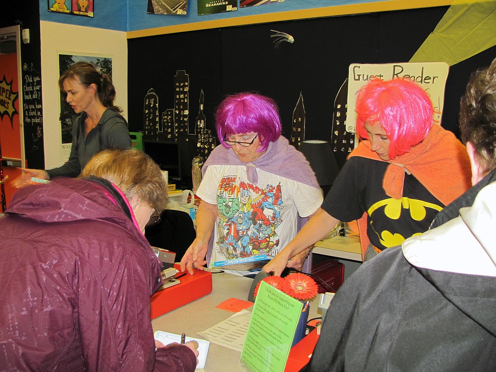 Wendi Coe, Jean Graham and Missy Shepherd (left to right) serve as volunteer cashiers during the Prune Hill book fair on Monday. School librarian Meghan Johnson said the mother and daughter team of Graham and Shepherd (in colorful costume for Superhero Dress Up Day) are working all-day, every day of the fair.