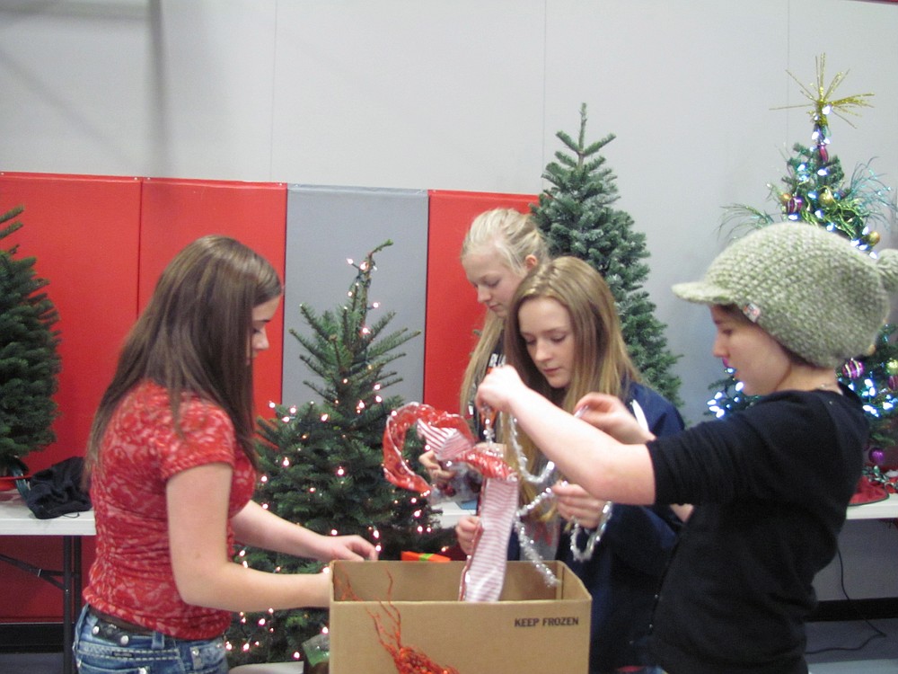Canyon Creek Middle School ASB representatives (clockwise, from left) Natalie Garner, Bridgette McCarthy, Danielle Smyth and Jeannine Jones decorate a tree in school colors of silver and red. It is the third year Canyon Creek ASB has participated.