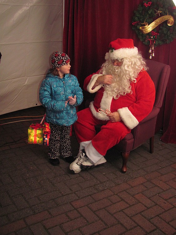 Santa Claus visited with children and distributed candy canes after the tree lighting ceremony. Complimentary photos, taken by Lisa Kuhlman with Windows On Life Photography, were provided by Riverview Community Bank.