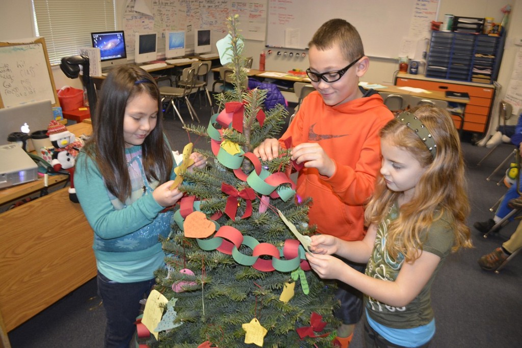 Cape Horn-Skye third-graders Ellison Wilkins, Holden Bea and Avery Berg put the finishing touches on a tree. The paper ornaments contained inspirational sayings, from famous people to the students themselves.