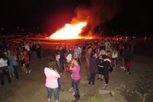 Washougal High School students gather around the fire to celebrate the return of the fall sports season Wednesday, at the former Hambleton Brothers Lumber Mill Property.