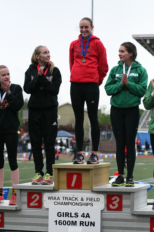Alexa Efraimson smiles on the podium as the annoucer says she broke the meet record and set the best time in the nation.