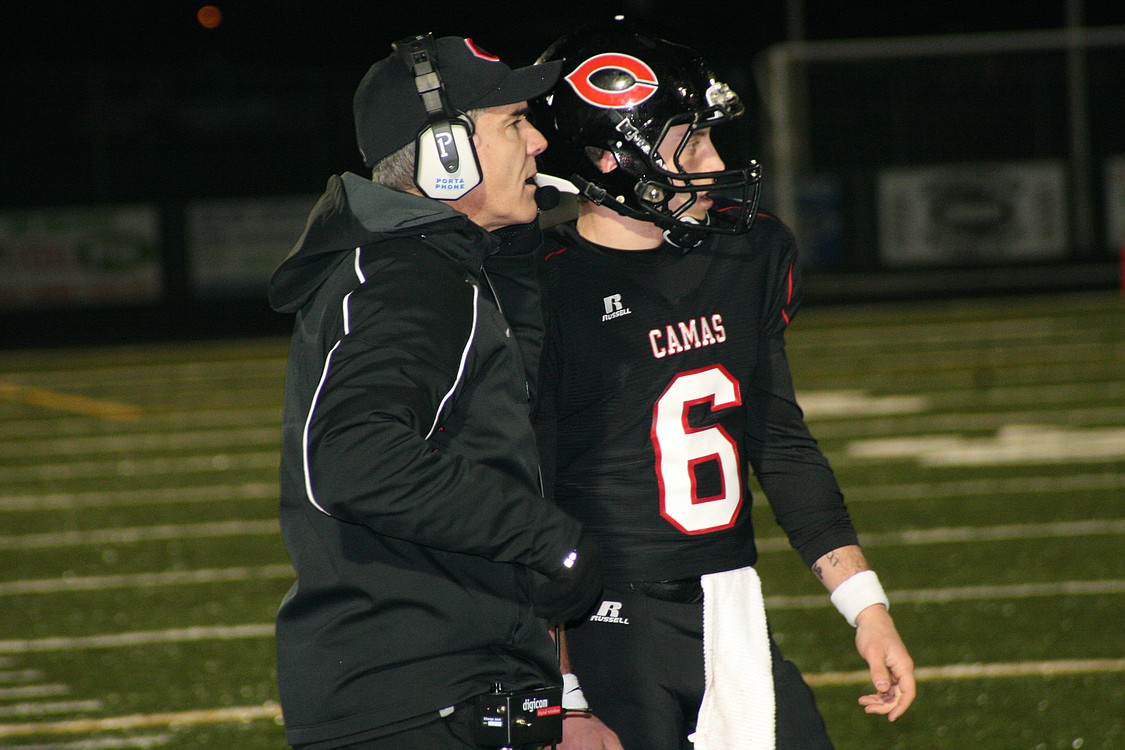 Head coach Jon Eagle converses with quarterback Tony Gennaro.