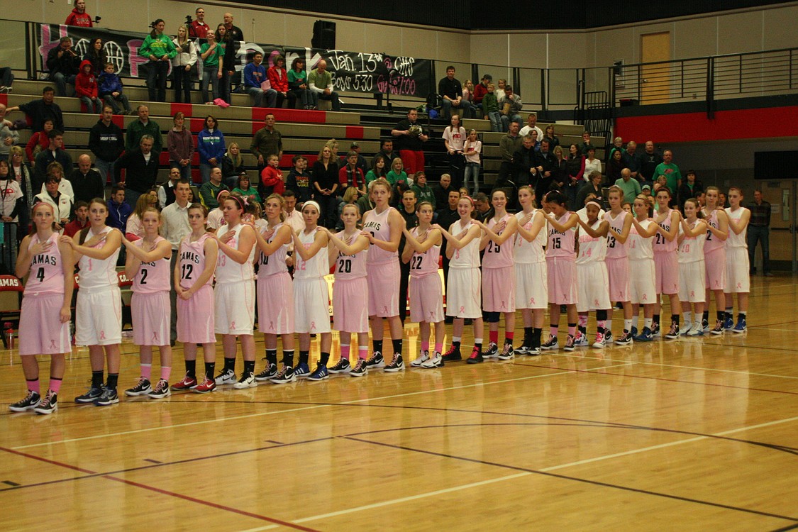 Camas and Mountain View girls basketball players share a moment of silence in honor of those who suffer from breast cancer.