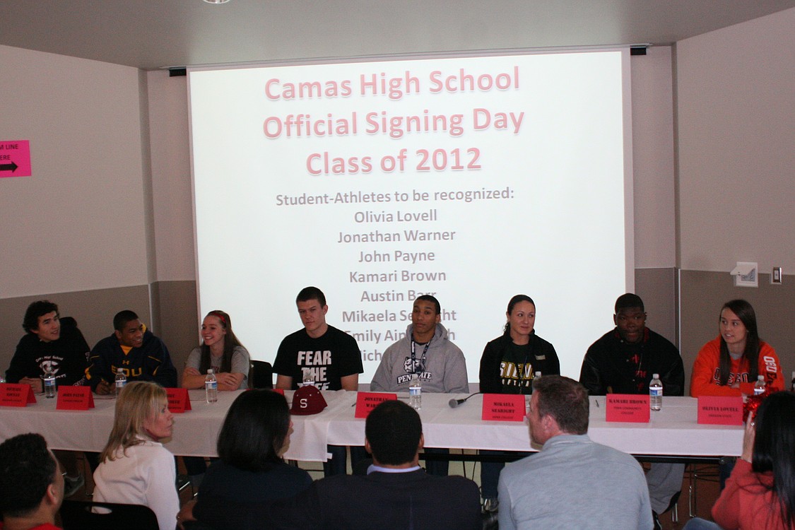 Left to right: Camas High School seniors Michael Koceja, John Payne, Emily Ainsworth, Austin Bar, Jonathan Warner, Mikaela Searight, Kamari Brown and Olivia Lovell sit at the table on National College Signing Day.