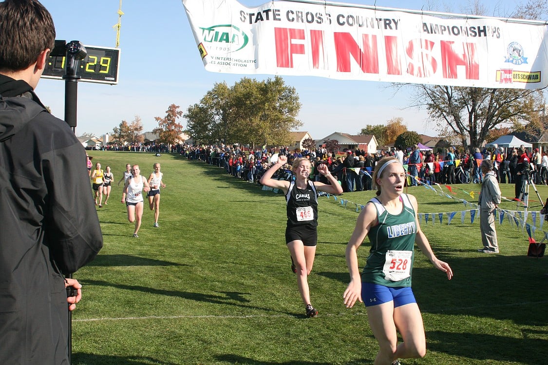 Lindsay Wourms throws her hands up in victory after beating two Glacier Peak runners to the finish line.