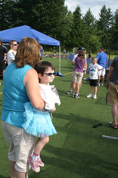 Spectators watch as friends and family members cross the finish line of the 2011 Lacamas Lake Half Marathon and 4 miler events on Sunday. All races started and finished at Camas High School. This marked the eighth year for the event, which drew more than 1,300 people and is organized by Fit Right NW.