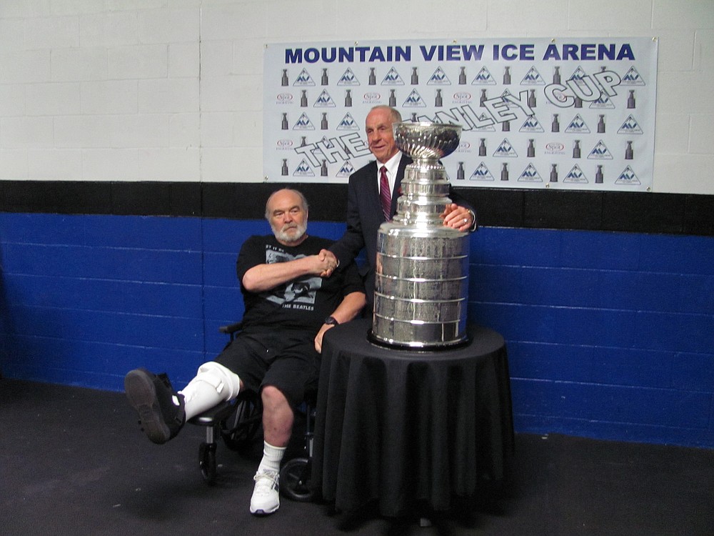 Tom McVie (right) shakes the hand of a hockey fan during Wednesday's Stanley Cup viewing at the Mountain View Ice Arena. McKie, a scout with the Boston Bruins, was in possession of the Cup for 24 hours. He wanted to bring it home to Vancouver.