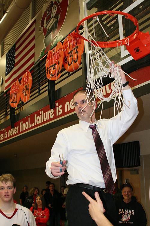 Head coach Scott Preuninger trims the net.