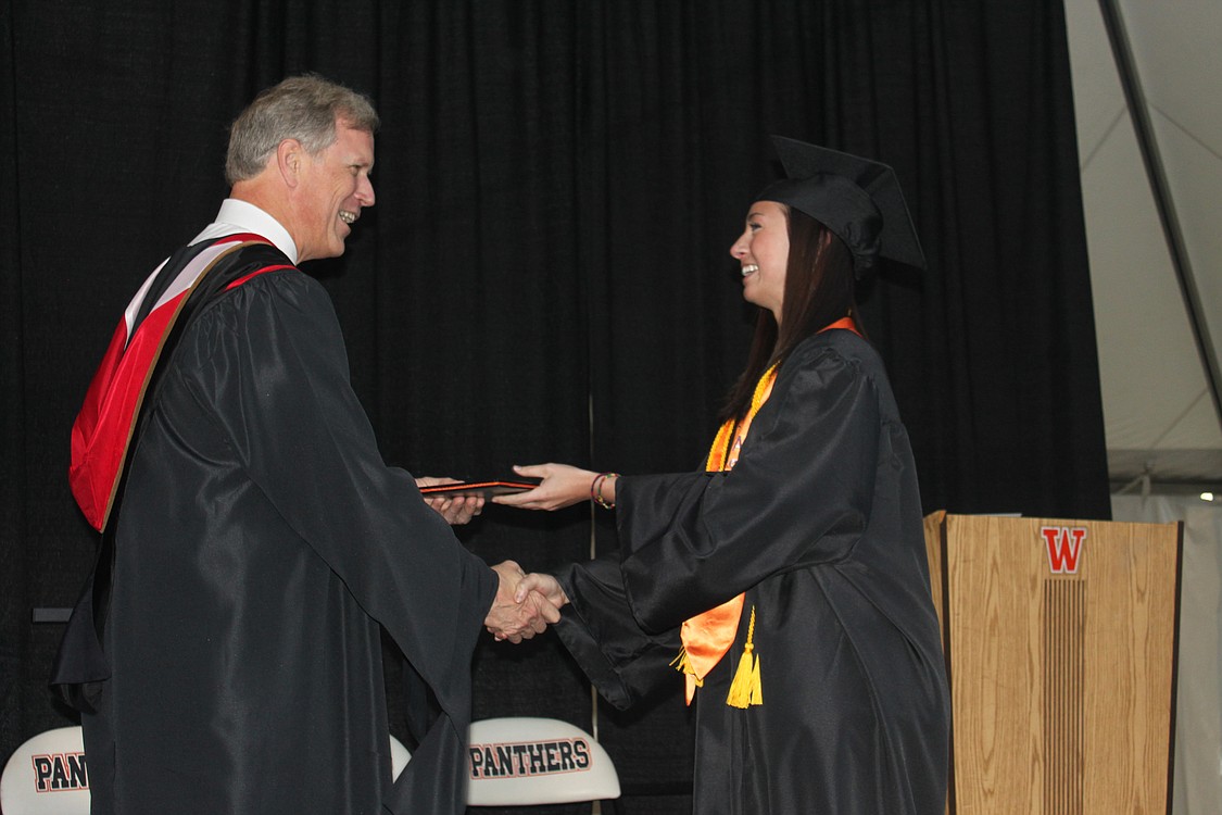 Chloe Kilgore accepts her diploma and a handshake from School Board President Blaine Peterson at the WHS graduation ceremony June 11.
