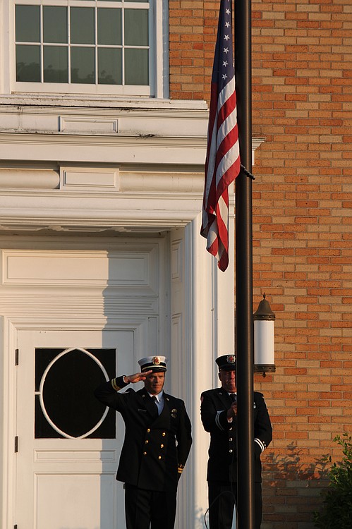 Camas Battalion Chief Allen Wolk (left) and Fire Capt. Chuck Bettis (right) raised the flag at the library to half-mast.  In addition to members of the Camas Fire Department, Sundays event included members of the Veterans of Foreign Wars Camas-Washougal Post 4278. Organizer Camas Firefighter/Paramedic Chris Richardson said Washougal Fire Department personnel staffed local stations so that CFD employees could participate in the memorial.