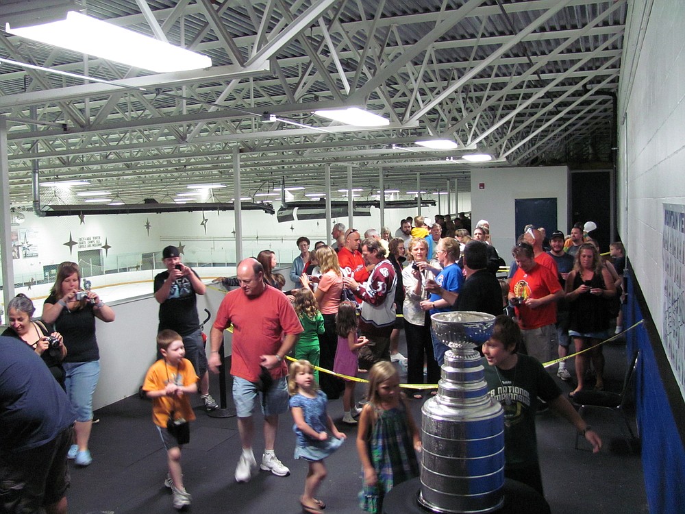 An excited family can hardly wait to get their picture by the Cup.