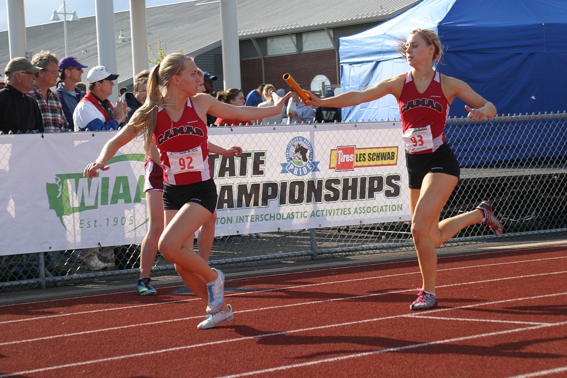 Sara Slayton (right) hands the baton to Austen Reiter (left) during the 1,600 relay state championship race.