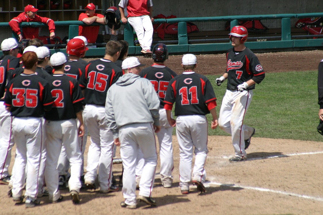 The Papermakers congratulate Logan Grindy at home plate after his second home run in the final four.