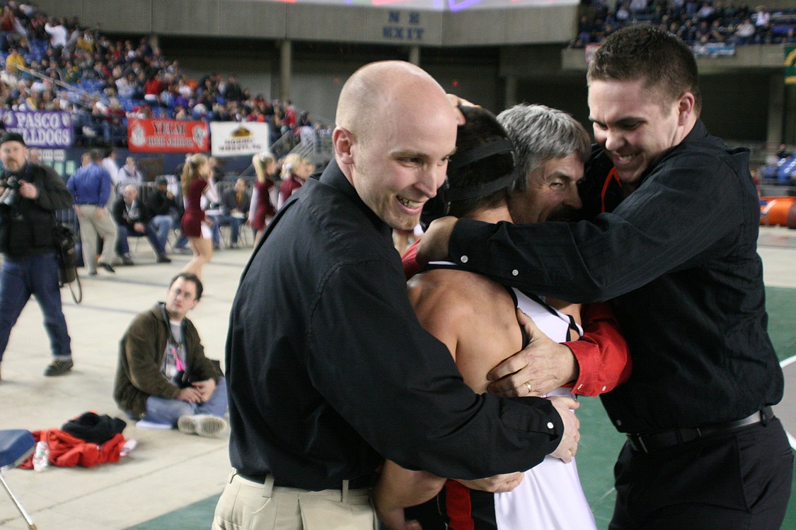 Camas coaches Alan Bohac, Glenn Hartman and Brody Faler (left to right) give Miguel Salamanca a bear hug.