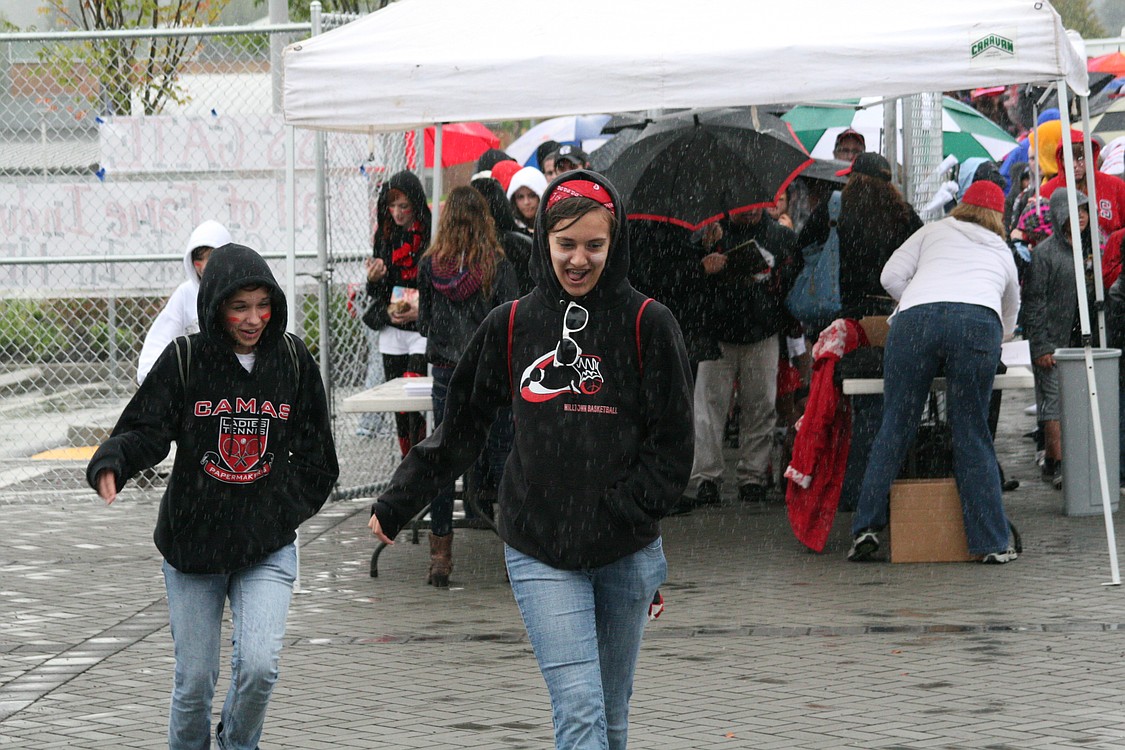 Excited fans for the grand opening of the new Doc Harris Stadium run for cover from the rain.