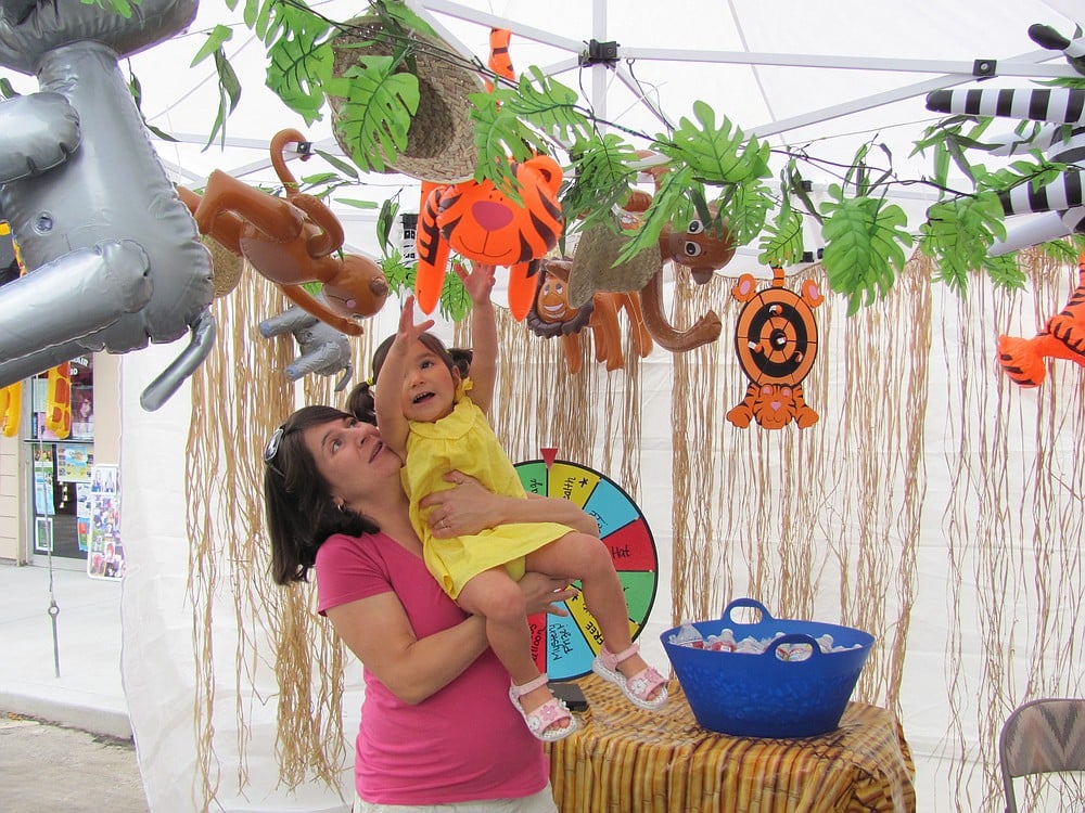 Joanna Duran gives her daughter, Delaney, a lift to look at the animal prizes offered by Pure Wellness, a chiropractic and massage clinic in Washougal.