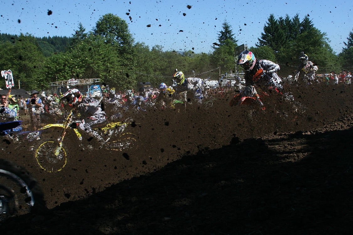 Riders, photographers and fans get caked with mud.