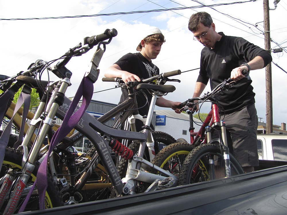 Corey Craig (left) of Washougal, and David Stiles (right), of Camas, load mountain bikes into a truck Friday, oustide Camas Bike and Sport.  They are among the bicyclists who participate in local group ride opportunities. Published in the May 11, 2010 edition.