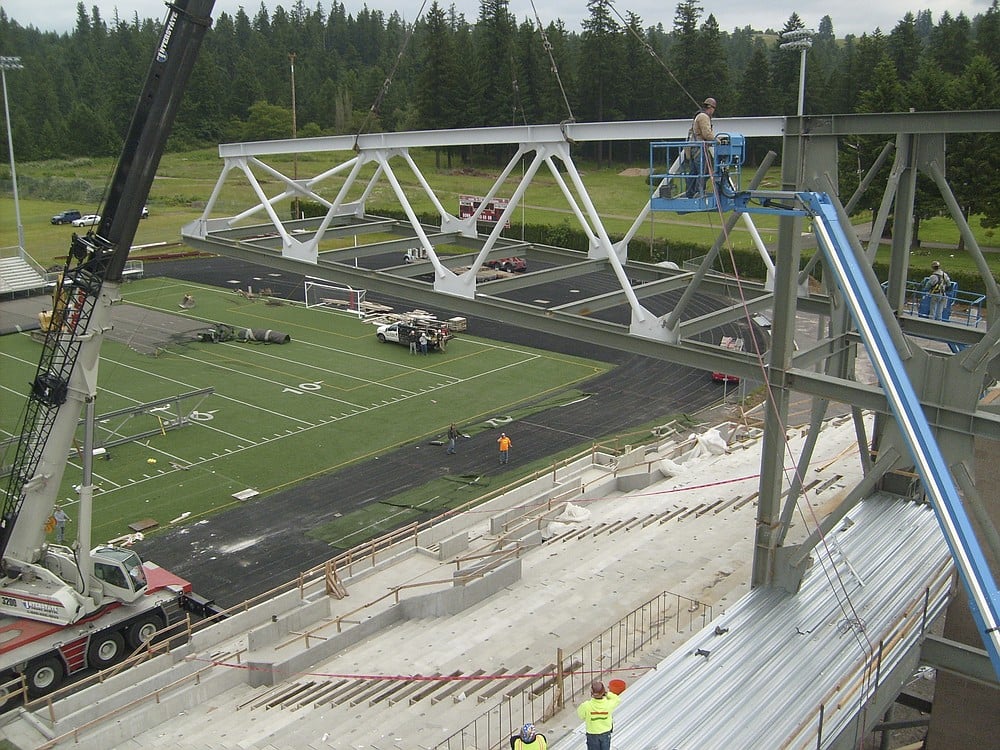 A birds eye view of a roofing panel being placed on Doc Harris Stadium.