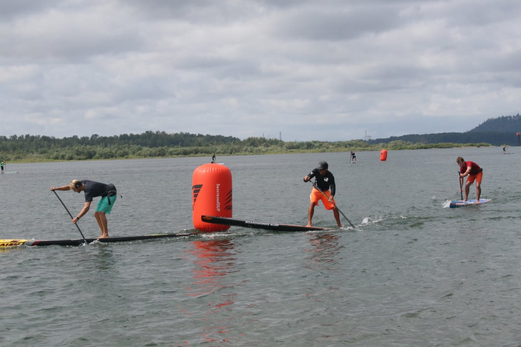 Long course challenge leaders Tucker Ingalls, Michael Tavares and Derek Fromm paddle around a buoy in the Columbia River.