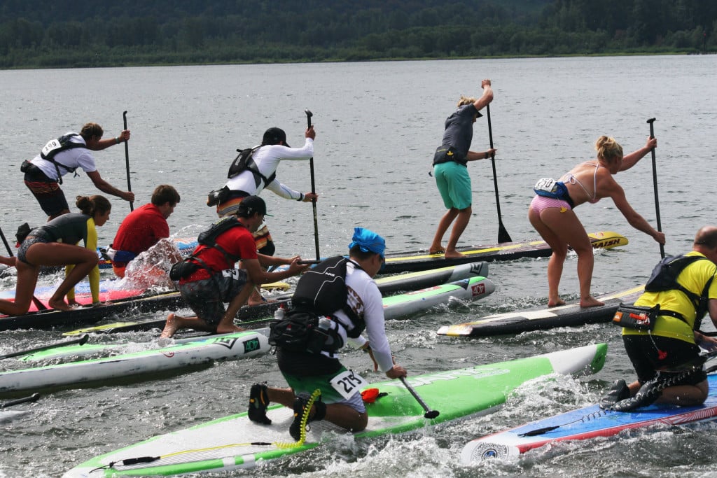Racers stand up on their boards and begin to paddle through the Columbia River during the Salmon Classic Sunday, off Cottonwood Beach in Washougal.