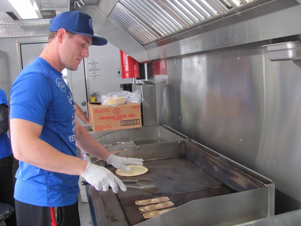 Adam Barlas prepares an order at Getta Gyro. The new food truck is a regular staple at the Vancouver Farmer's Market at Columbia Tech Center. He is assisted by mom, Elayne and dad, Harry. The Barlas family are Camas residents. 