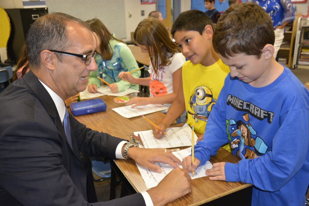 Mike Stromme, Washougal School District superintendent, helps fourth graders Dominic Stub and Jayden Iniquez with an assignment on the first day of school. 