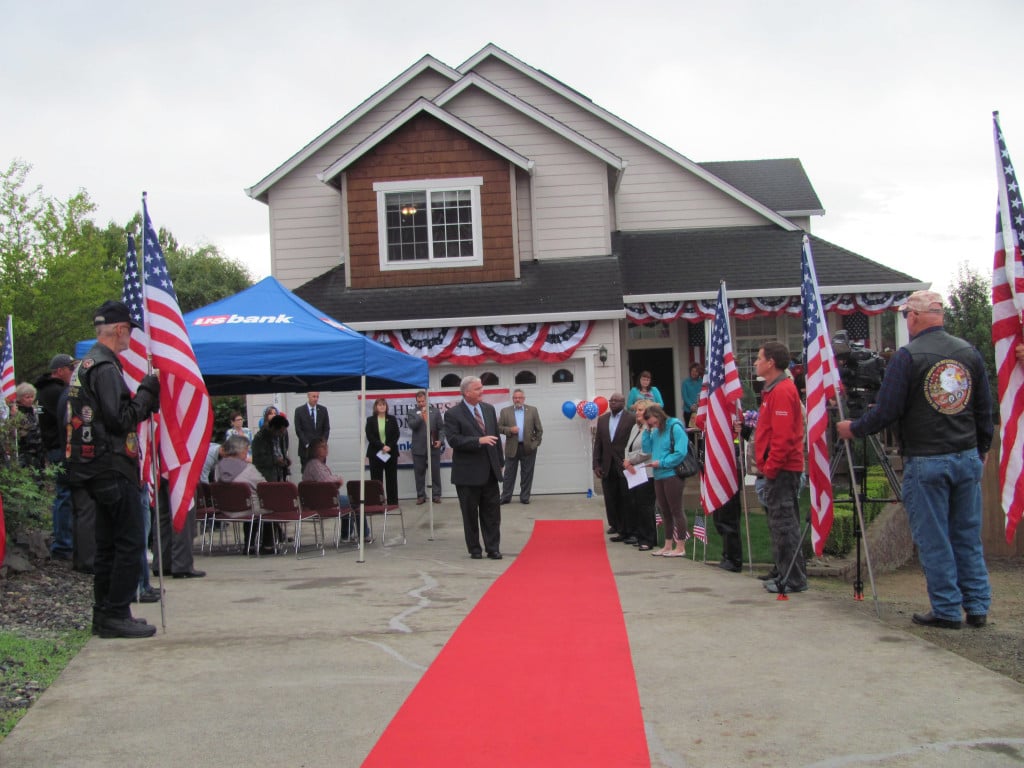 Thomas Kilgannon, president of the Fredom Alliance, the Patriot Guard Riders and local dignitaries wait to welcome the Collins family to their newly renovated home.                                