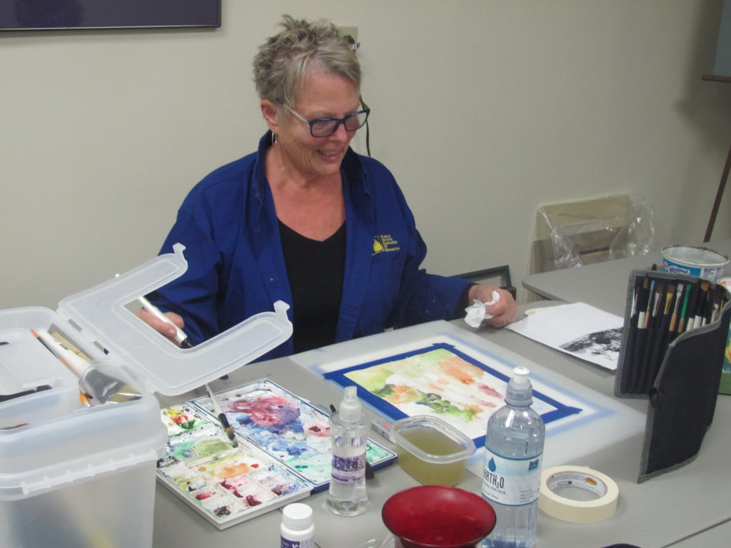  Linda Peters works on an autumn themed painting.                               