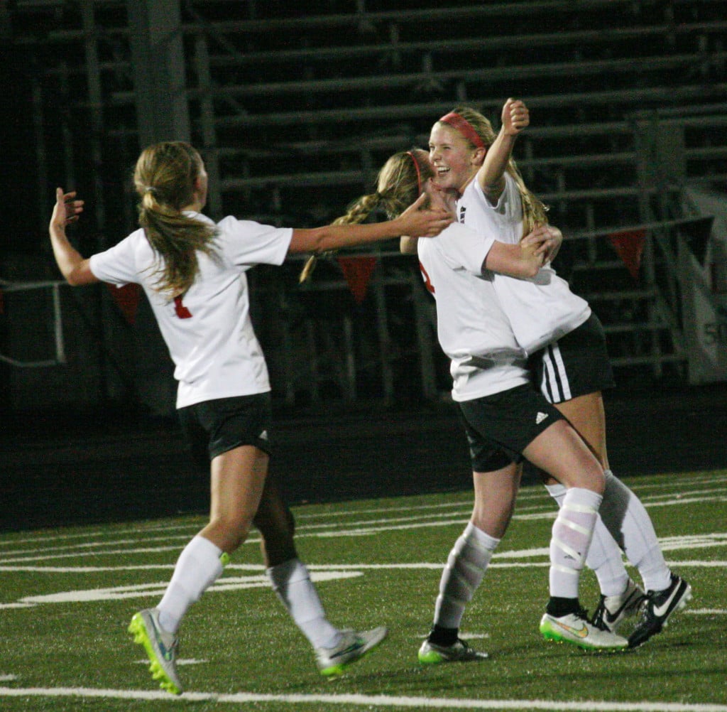 Hannah Taie gets hugs from Rylee MacDonald and Sabine Postma after netting a free kick in the final minute of the game for Camas.