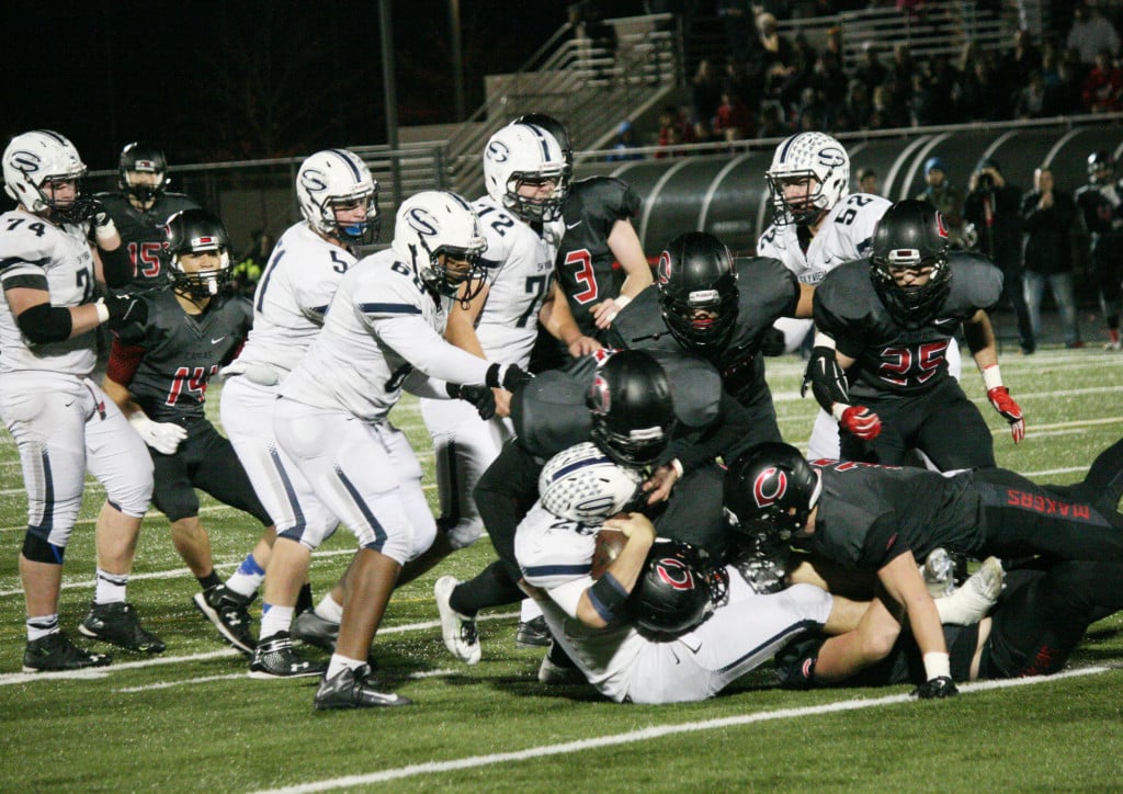 Four Papermakers bring down the ball handler for Skyview Saturday, at Doc Harris Stadium. Camas weathered the Storm, and emerged with a 29-22 victory in the first round of the state tournament.
