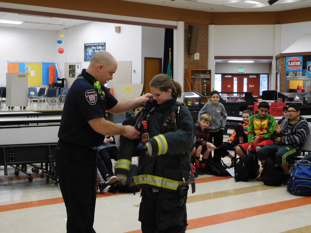 Greg Payne, a firefighter with the Camas-Washougal Fire Department, helps seventh-grader Hailey Bachteler put on the required equipment used for entering a burning structure. It can weigh up to 80 pounds. 