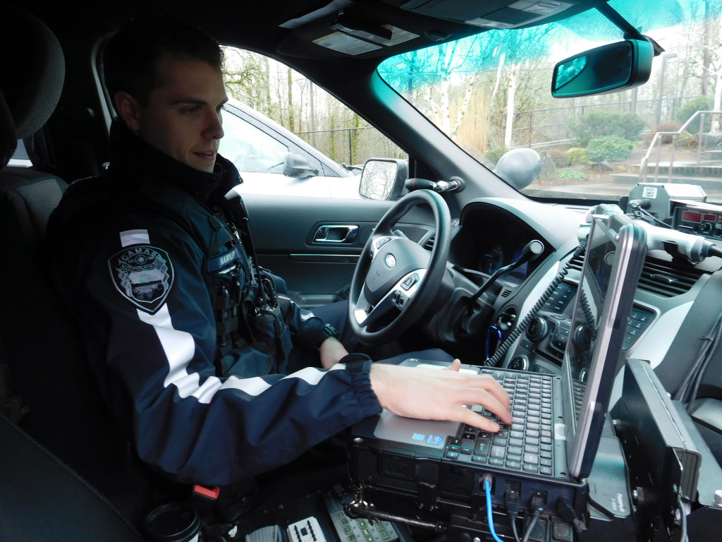 Camas Police Officer Casey Handley uses a laptop computer in his patrol car to view the locations and descriptions of calls that have been dispatched. He is a former WPD reserve officer.