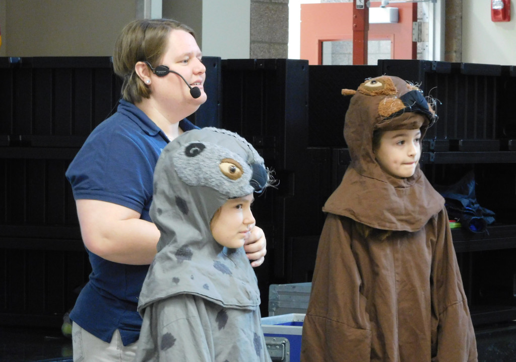 Jenni Remillard, aquarium education specialist, has student volunteers dress up in costumes to help their classmates create a visual image of the differences between seals, sea otters and sea lions.
