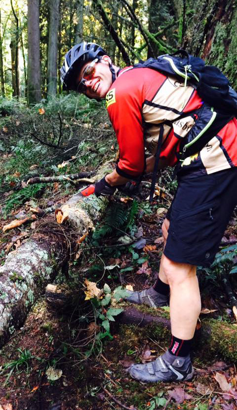 Trail bike rider Chris Lehner removes a fallen tree limb, one of the most common issues seen at local trails, especially after a big storm.