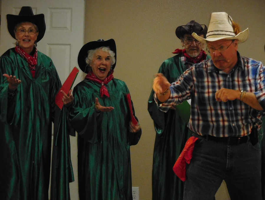 The auctioneer (Greg Forbes) calls over  Harriet Walker, Nancy Rickard, Chuck Stavis, who are on their way to choir practice, to show them his auctioneering skills.