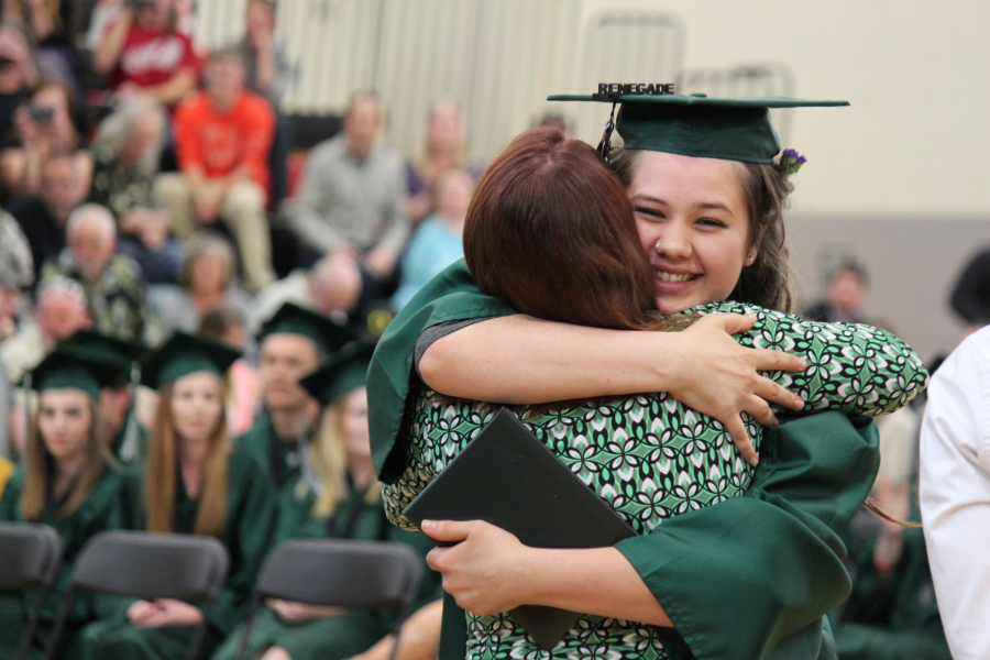 Leyah Ellis hugs teacher Monica Winkley after receiving her diploma during the Hayes Freedom High School graduation ceremony on Saturday afternoon. She was one of 39 students who walked across the stage. 
