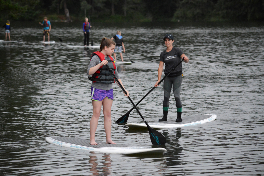 Lydia Stuart of Sweetwater SUP (right) instructs Grace Meyer (left) during a 2-hour clinic Friday, at Lacamas Lake. Summer hours are from 11 a.m. to 6 p.m., weather permitting, seven days a week, at Heritage Park. Paddle boards and kayaks are available to rent for $25 an hour. 