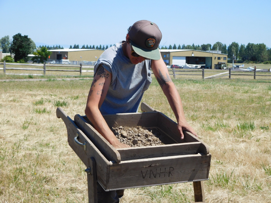 A student sifts through dirt to uncover potential artifacts from the Spruce Mill site at Fort Vancouver. 