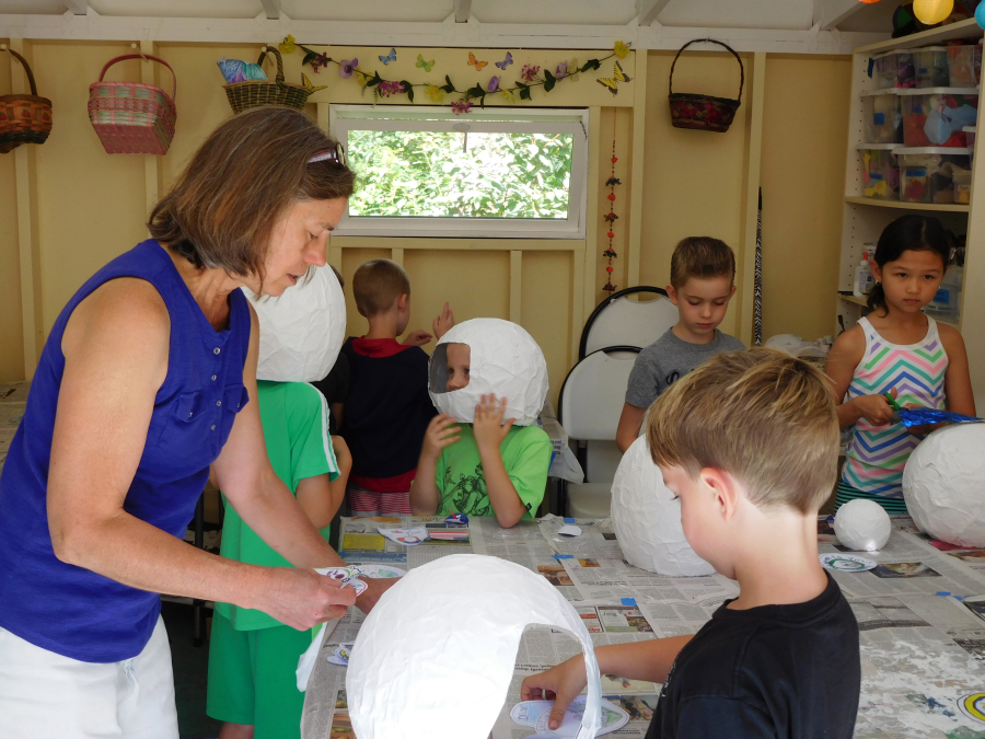 Kathy Marty, director at Camp Windy Hill, assists 6-year-old Dean Lanier with his astronaut helmet during space camp. Marty offers several themed summer camps at her rural Washougal 5 acre property.