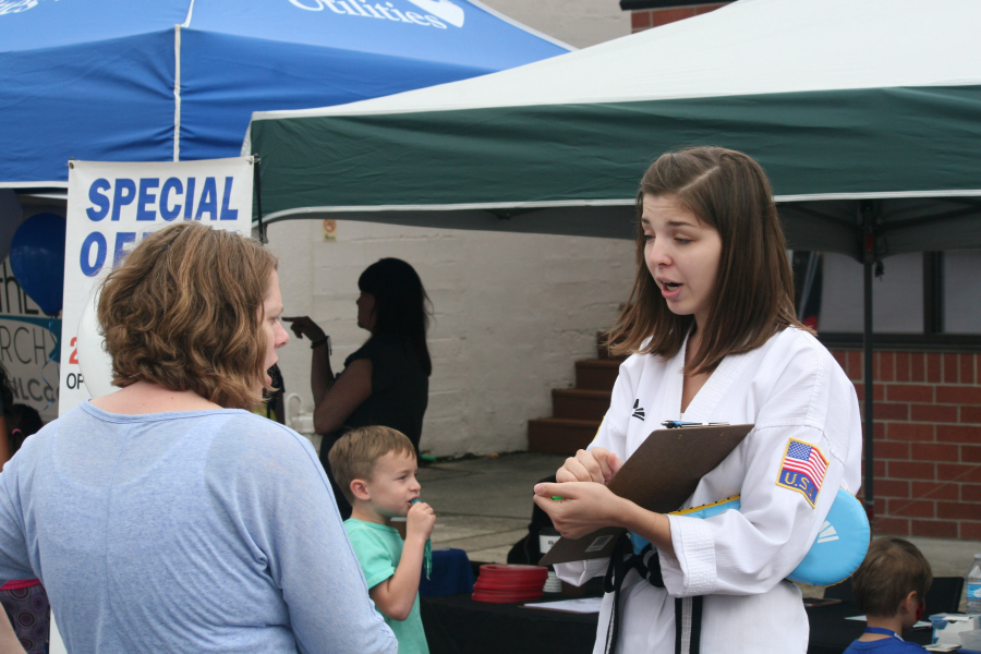 A representative from World Class Martial Arts of Vancouver talks to patrons on Friday. World Class Martial Arts is preparing to open a new location in Orchards on Aug. 1.