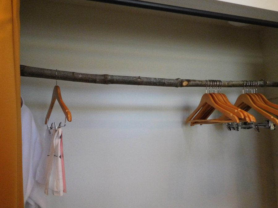 In the spirit of staying true to the treehouse theme, a branch is used as a clothing bar in the bathroom closet.